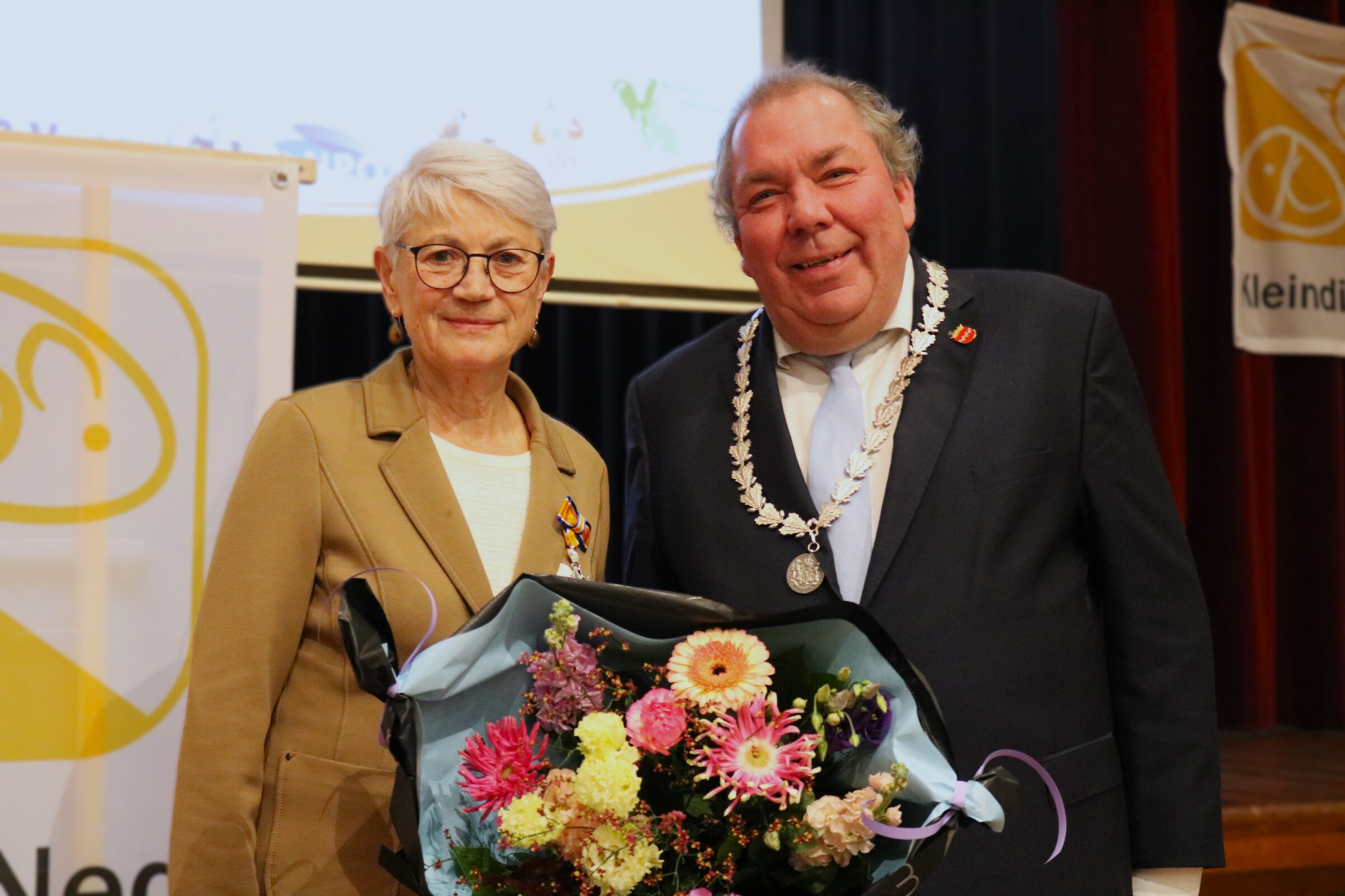 Paula Polman ontvangt lintje uit handen van burgemeester Ostendorp.